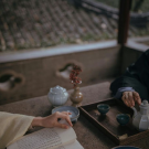 An image of two figures having a traditional tea
