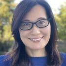 A woman wearing glasses smiling at the camera